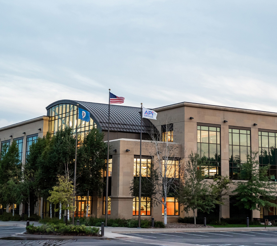 The headquarters building of APi Group with three flag poles.