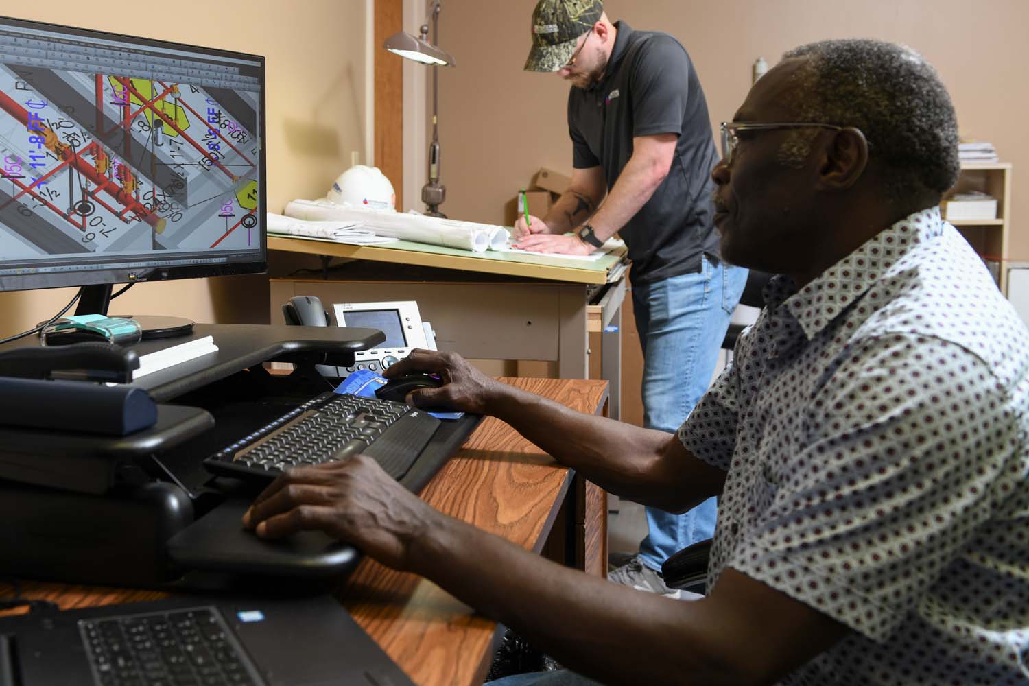 An employee saws metal piping and sparks fly.