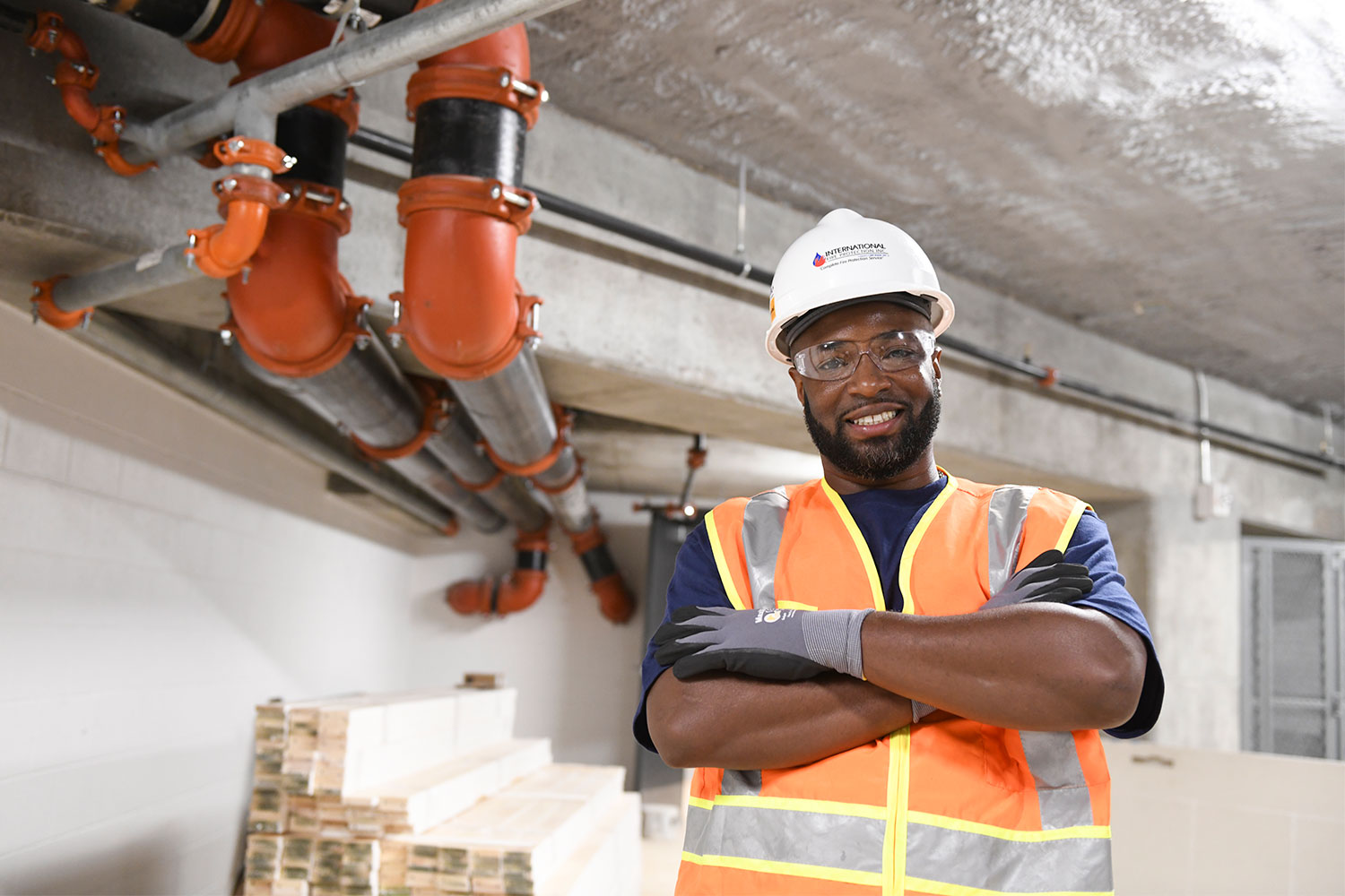 A coworker wearing safety gear on a job site for International Fire Protection, Inc.