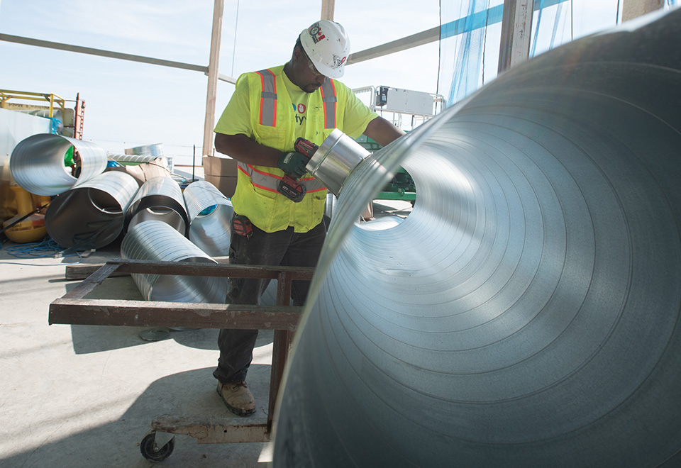 A coworker assembles a unit on the job site.